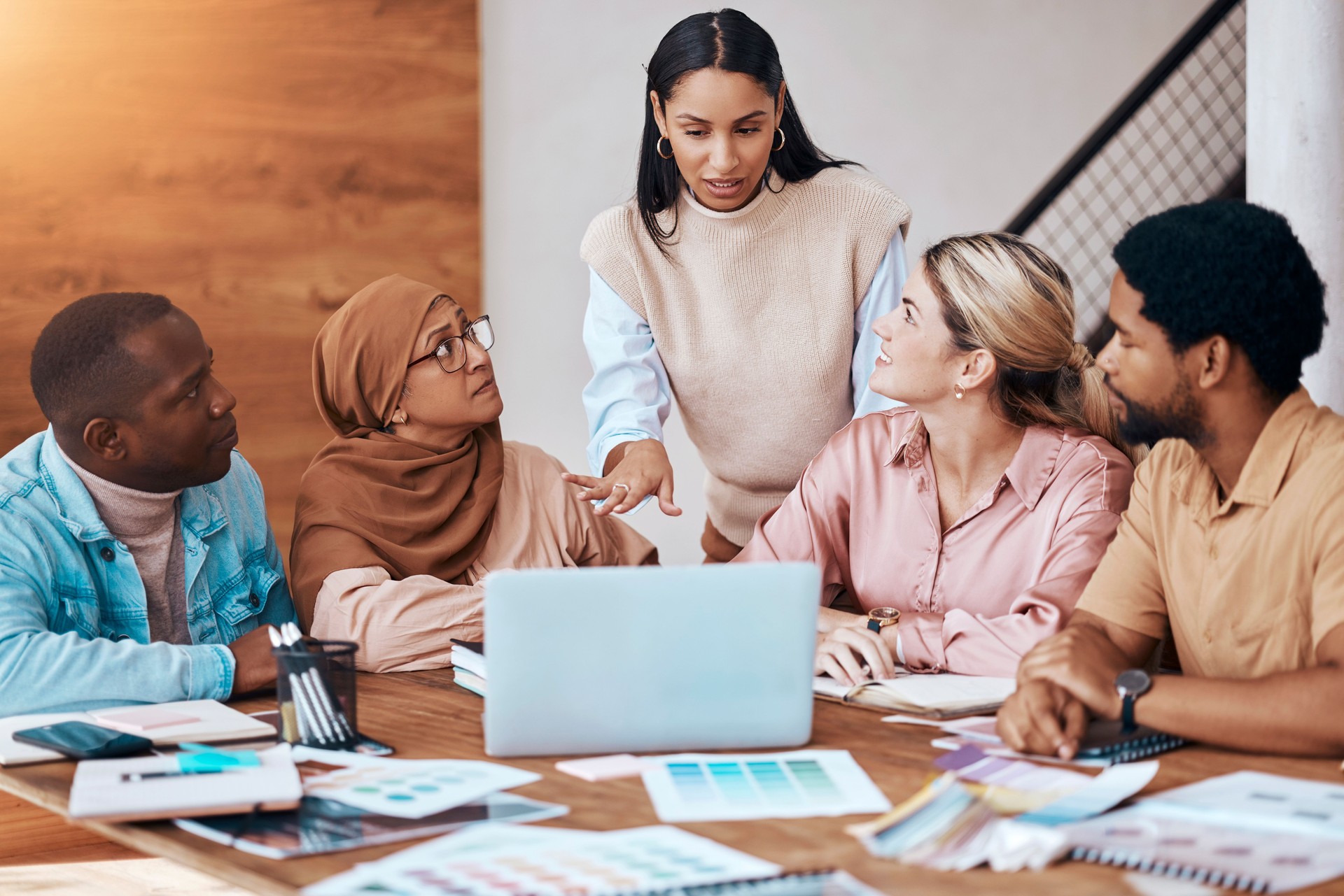 Meeting, strategy and business woman in a presentation talking and planning startup company data or paperwork. Diversity, discussion and group of people, team or employees brainstorming for teamwork